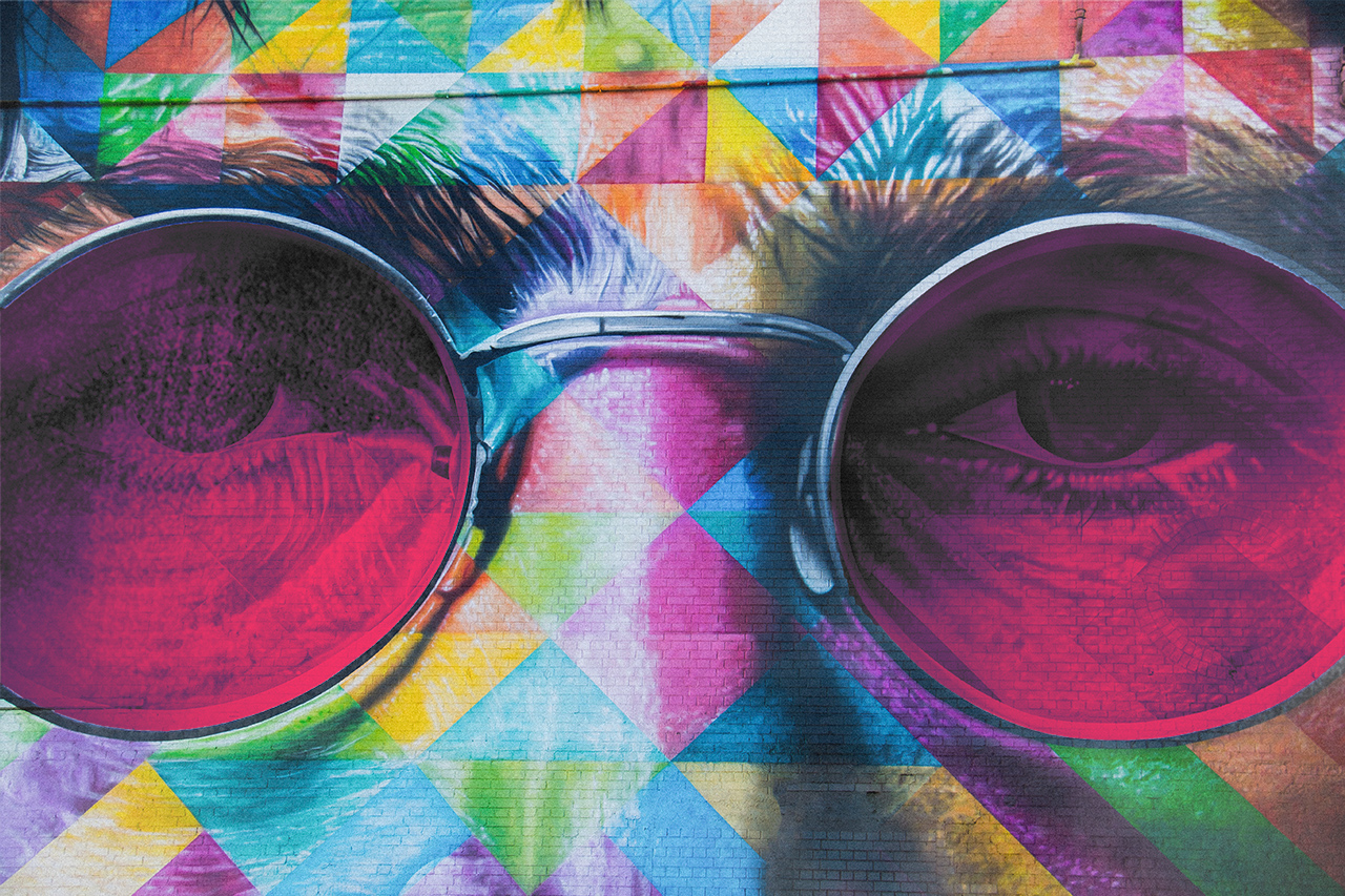 Art on a wall with man's face wearing glasses