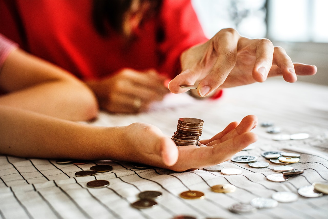 Hands of two people counting currency coins