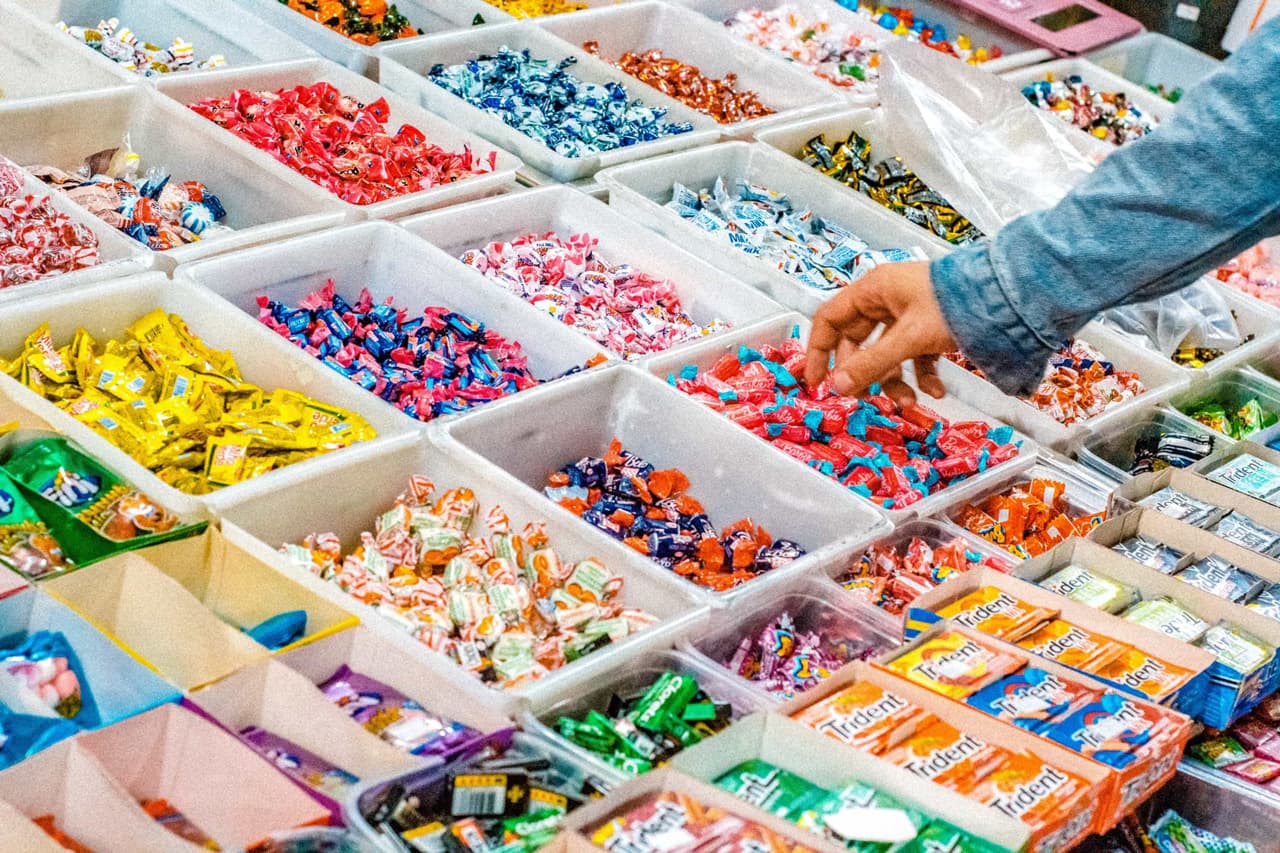 Person selecting amongst an array of multiple collections of chocolate candies