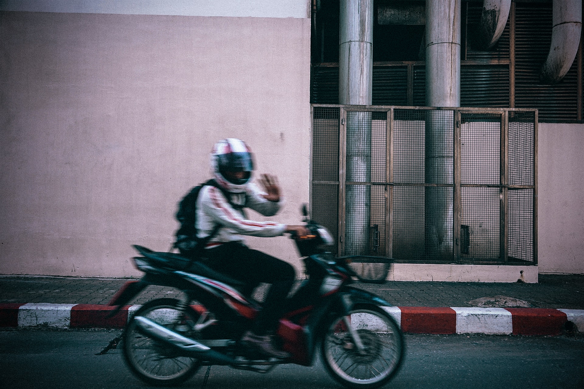 Guy waving his hand from a moving vehicle